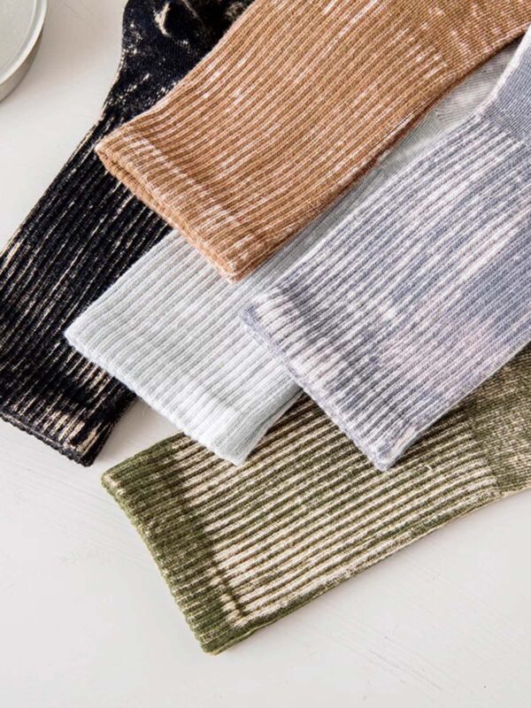 A set of five ribbed velvet socks in different colors—black, camel brown, light gray, silvery lavender, and olive green—neatly laid out on a light surface.